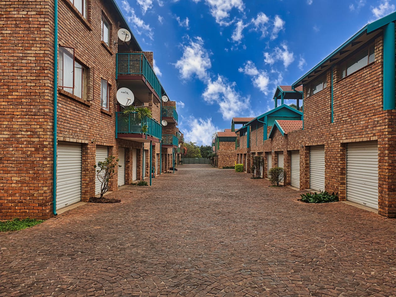 Brick apartment complex exterior with balconies and garages — for apartment communities, every day a unit sits vacant is direct revenue loss that virtual tours can measurably reduce
