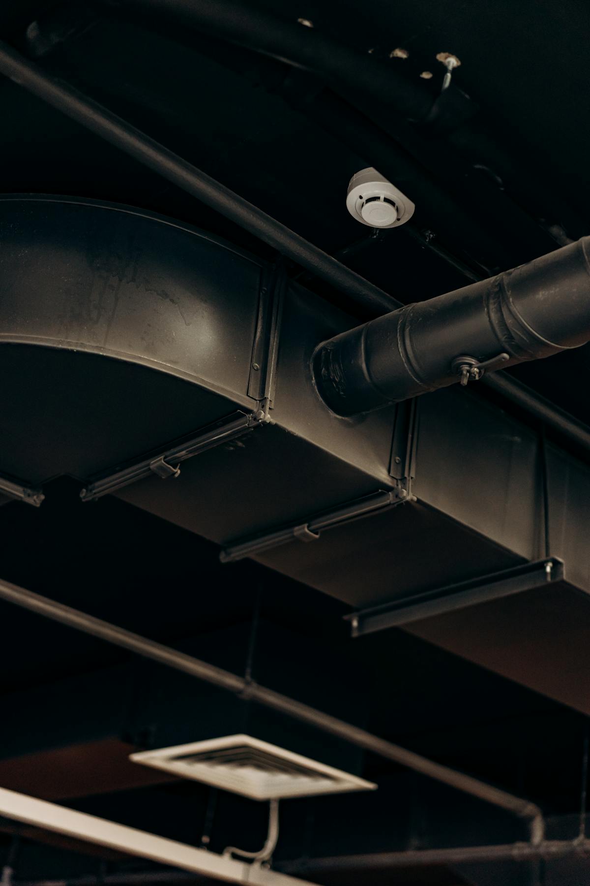Exposed mechanical, electrical, and plumbing systems in a commercial building ceiling during renovation