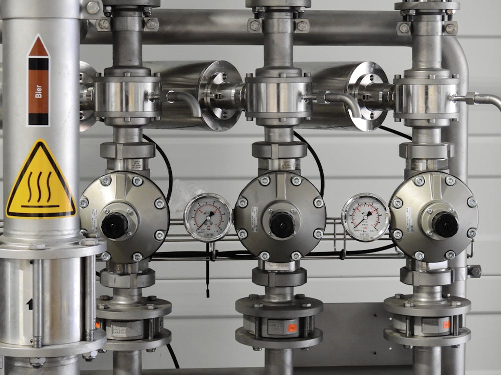 Metal pipes with pressure gauges and shut-off valves in a commercial mechanical room