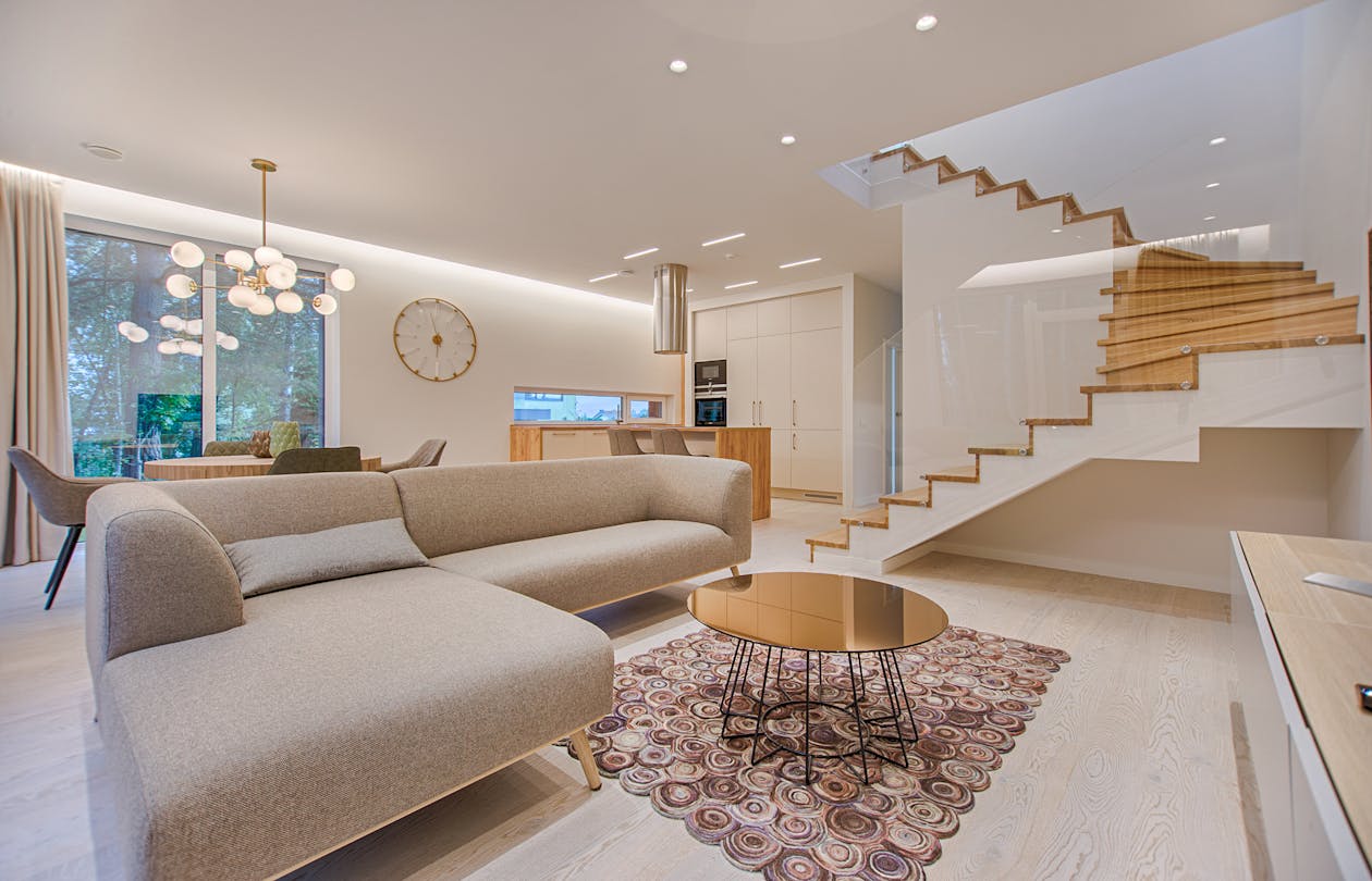 Modern open-plan living room with staircase, recessed lighting, and large windows — an ideal space for demonstrating Matterport scan positioning
