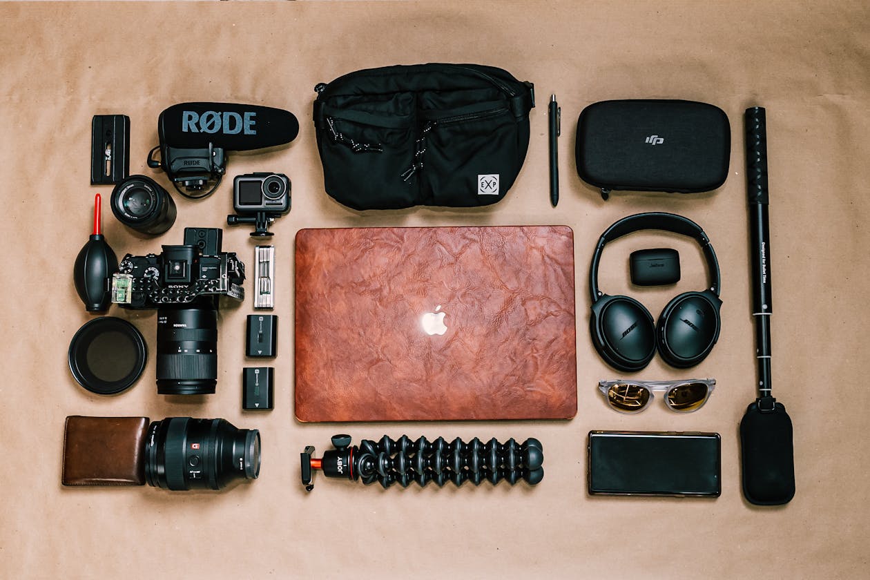 Professional photography and videography equipment flat lay including camera, lenses, tripod, laptop, and accessories for a virtual tour business