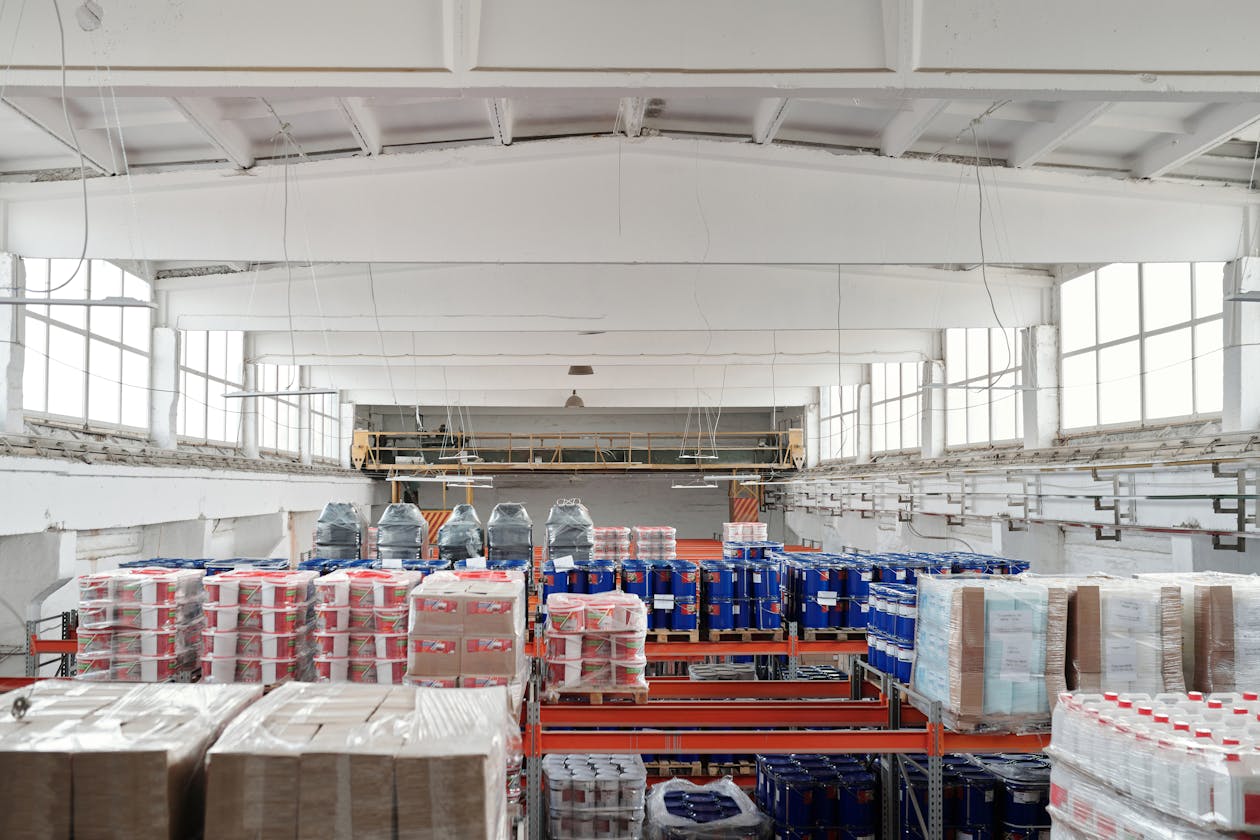 Large commercial warehouse interior with high ceilings, industrial shelving, and pallet racking — commercial spaces like these require different Matterport scanning approaches than residential properties