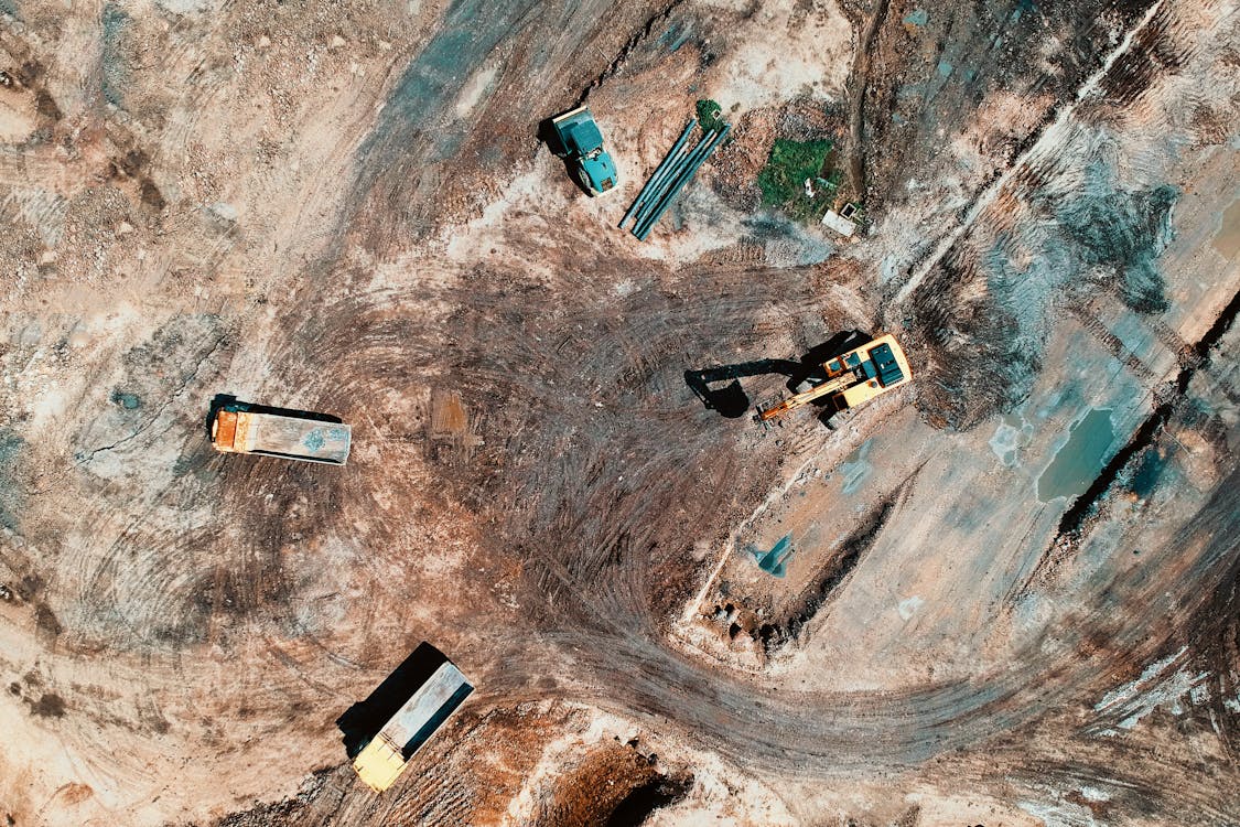 Aerial view of construction earthmoving site with excavators and dump trucks