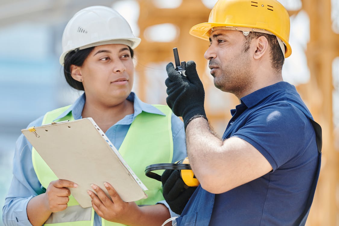 Construction professionals in hardhats discussing project on job site