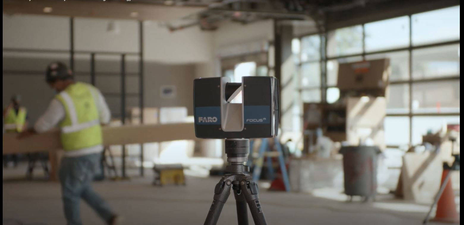 FARO Focus 3D laser scanner on tripod capturing scan data inside a commercial building under construction