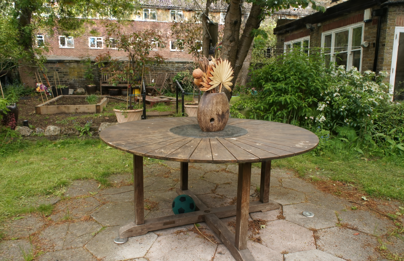 Gaussian Splatting render of a garden scene with table and foliage, demonstrating photorealistic quality from the INRIA research paper