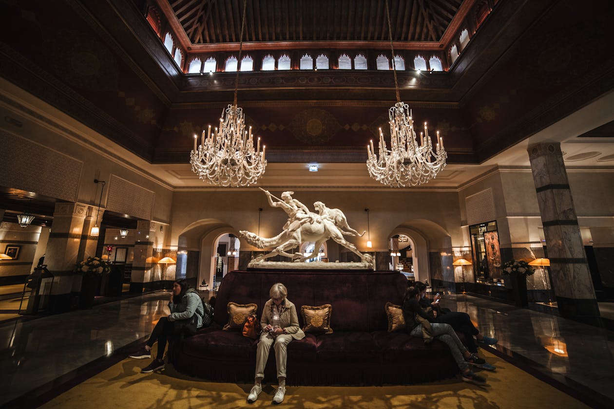 Grand luxury hotel lobby with crystal chandeliers, marble columns, and classical sculpture — hotels and hospitality businesses see significant engagement increases from virtual tours