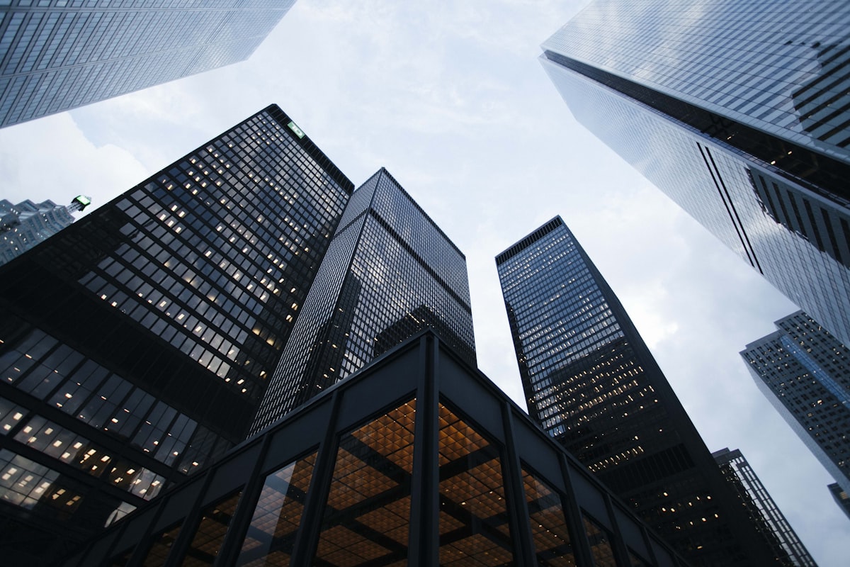 Upward view of modern commercial office buildings and skyscrapers with glass facades representing the commercial real estate industry