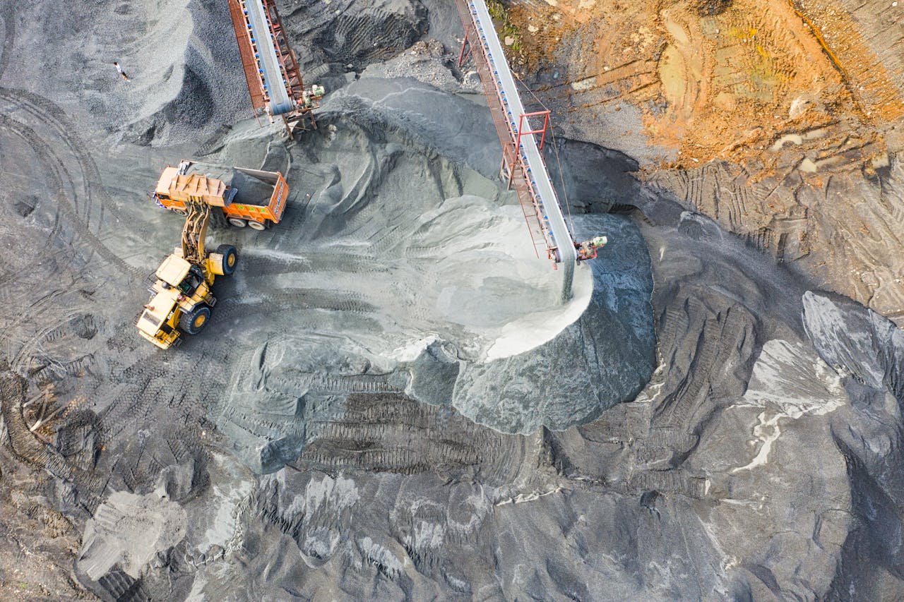 Aerial view of an open-pit mine with excavation equipment and stockpiles — drone LiDAR surveys these sites without halting operations
