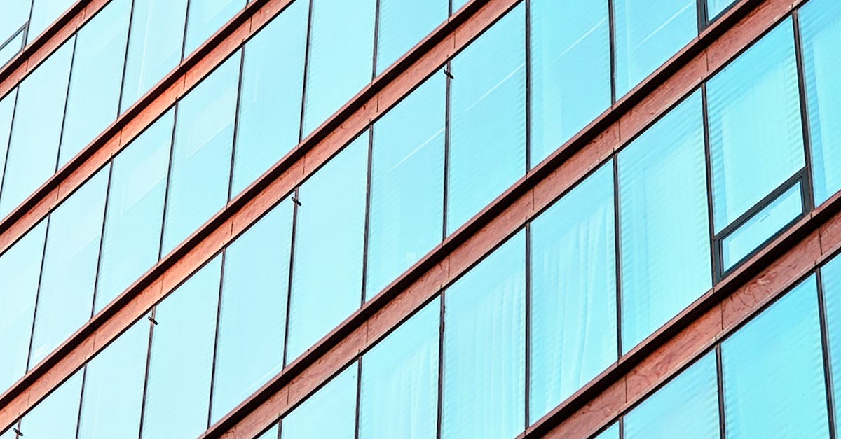 Modern glass building facade with extensive reflective windows that challenge laser scanning accuracy