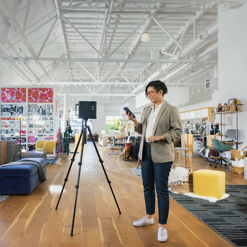 Professional technician scanning a retail showroom space with a Matterport camera on a tripod