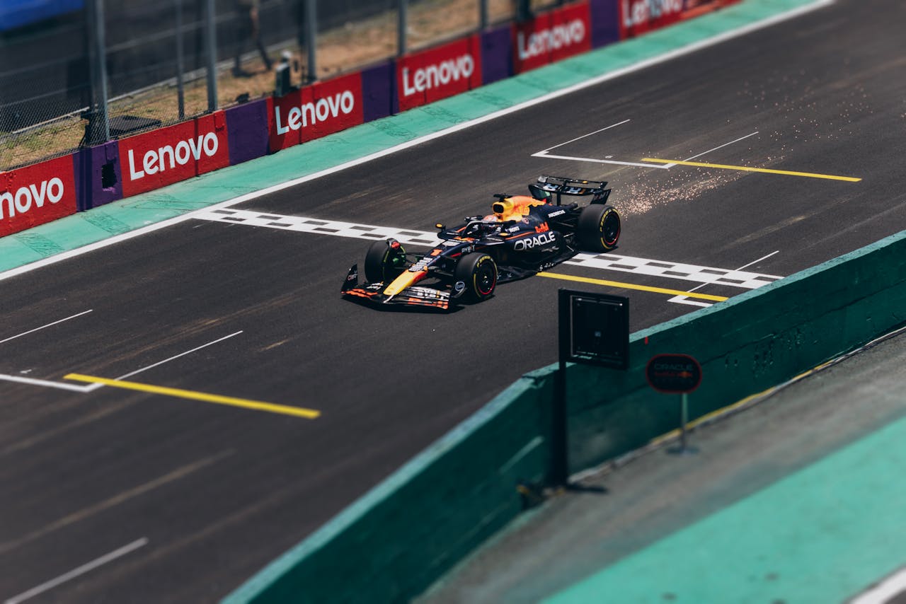Formula 1 car racing past safety barriers and run-off area — the infrastructure documented by 3D scanning for safety compliance