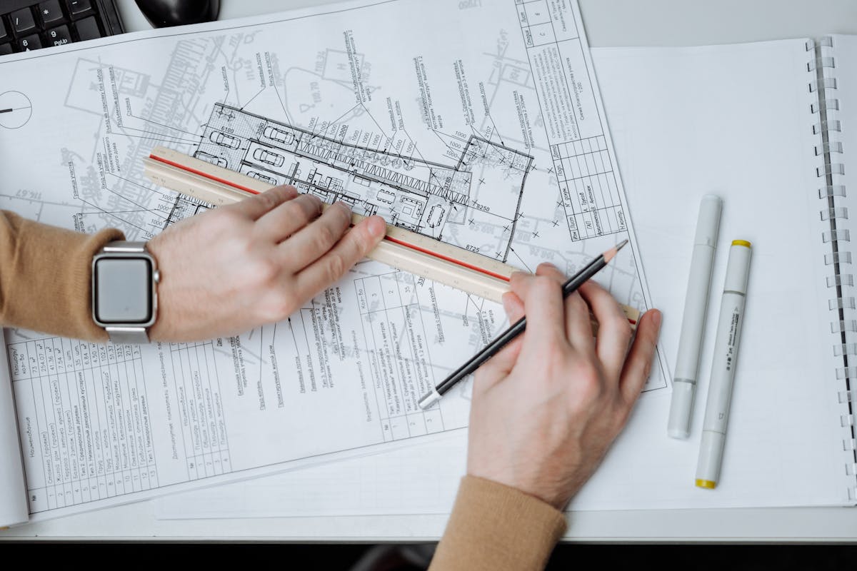 Architect reviewing detailed engineering floor plans with precision measuring tools