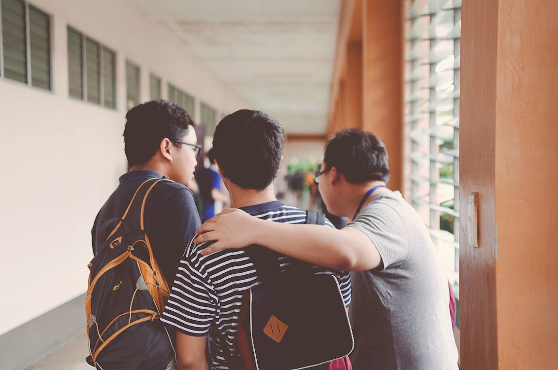 Students walking through a school corridor with backpacks