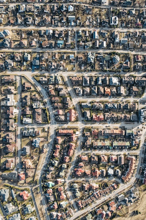 High-angle aerial view of a dense suburban neighborhood showing oblique perspective of buildings and streets
