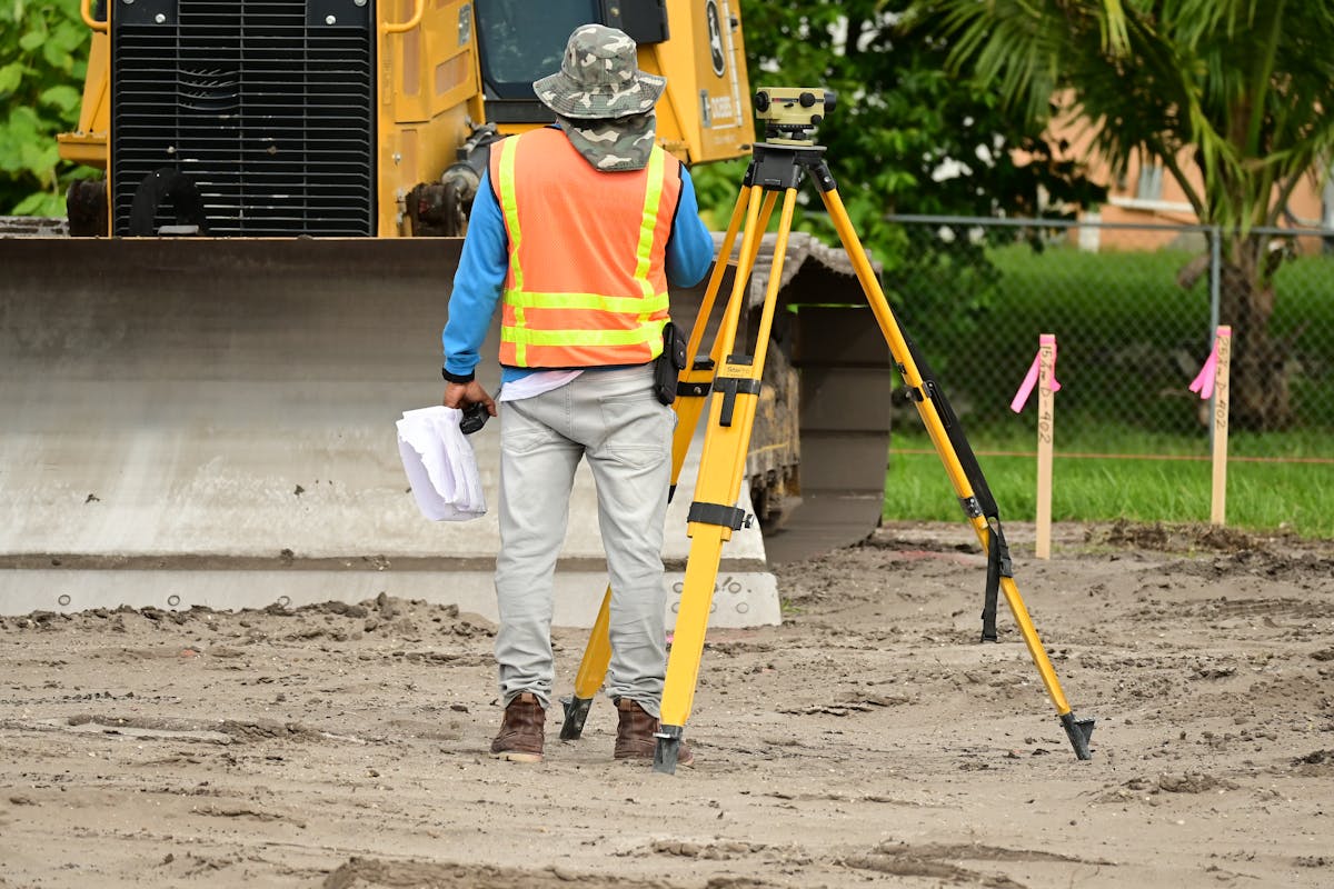 Surveyor using professional total station equipment at a construction site for precise measurement