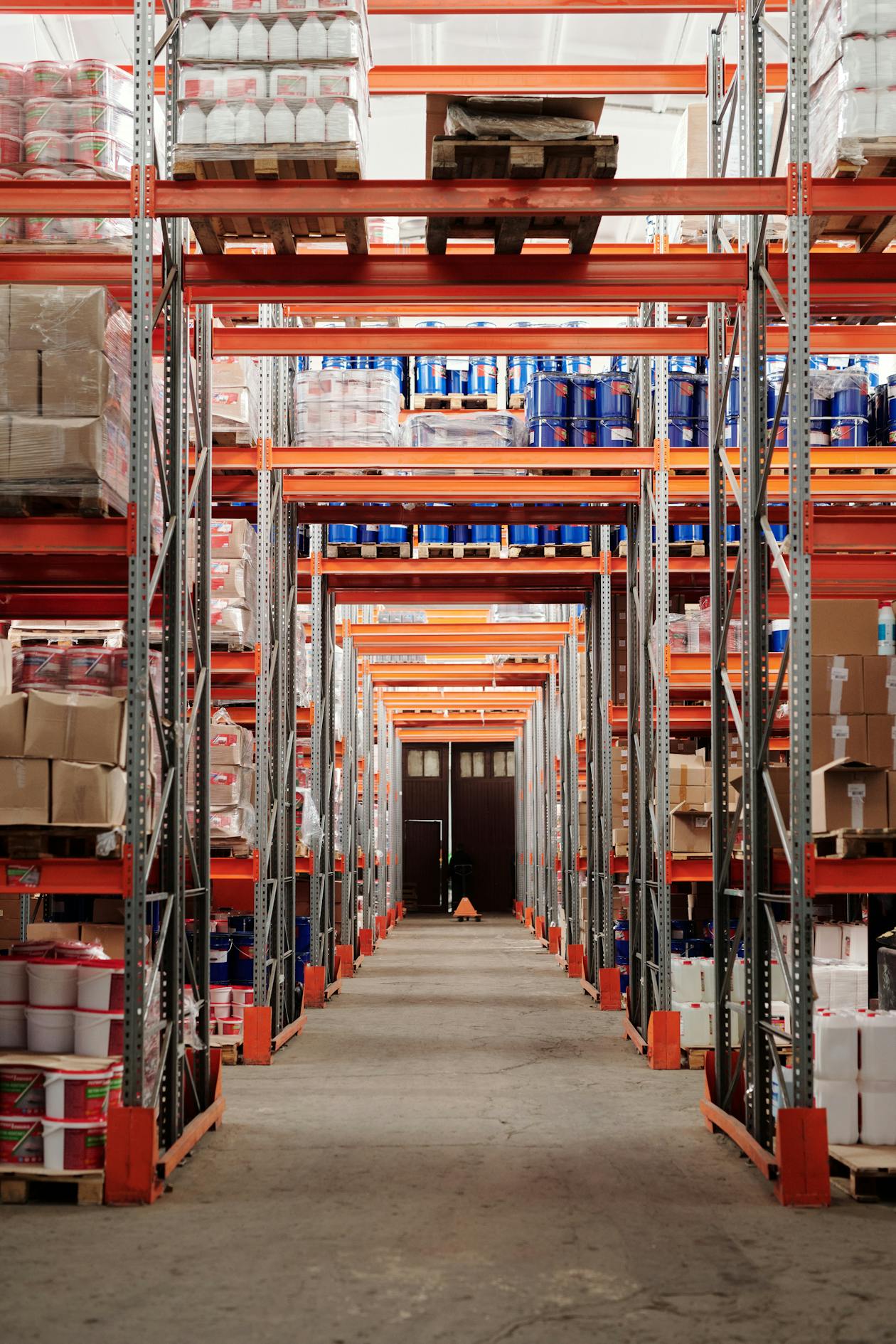 Large warehouse interior with tall orange shelving racks and organized inventory — a commercial space that benefits from professional scanning