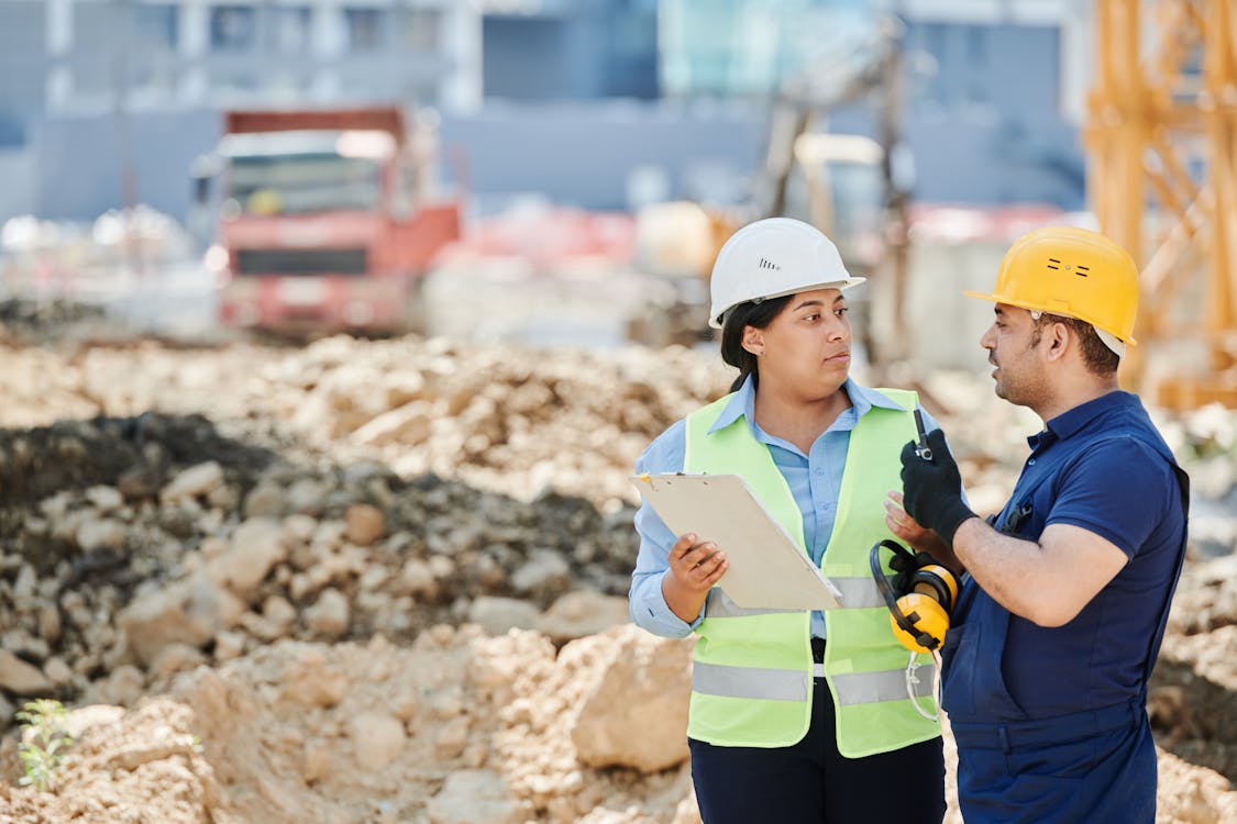 Workers discussing plans at construction site