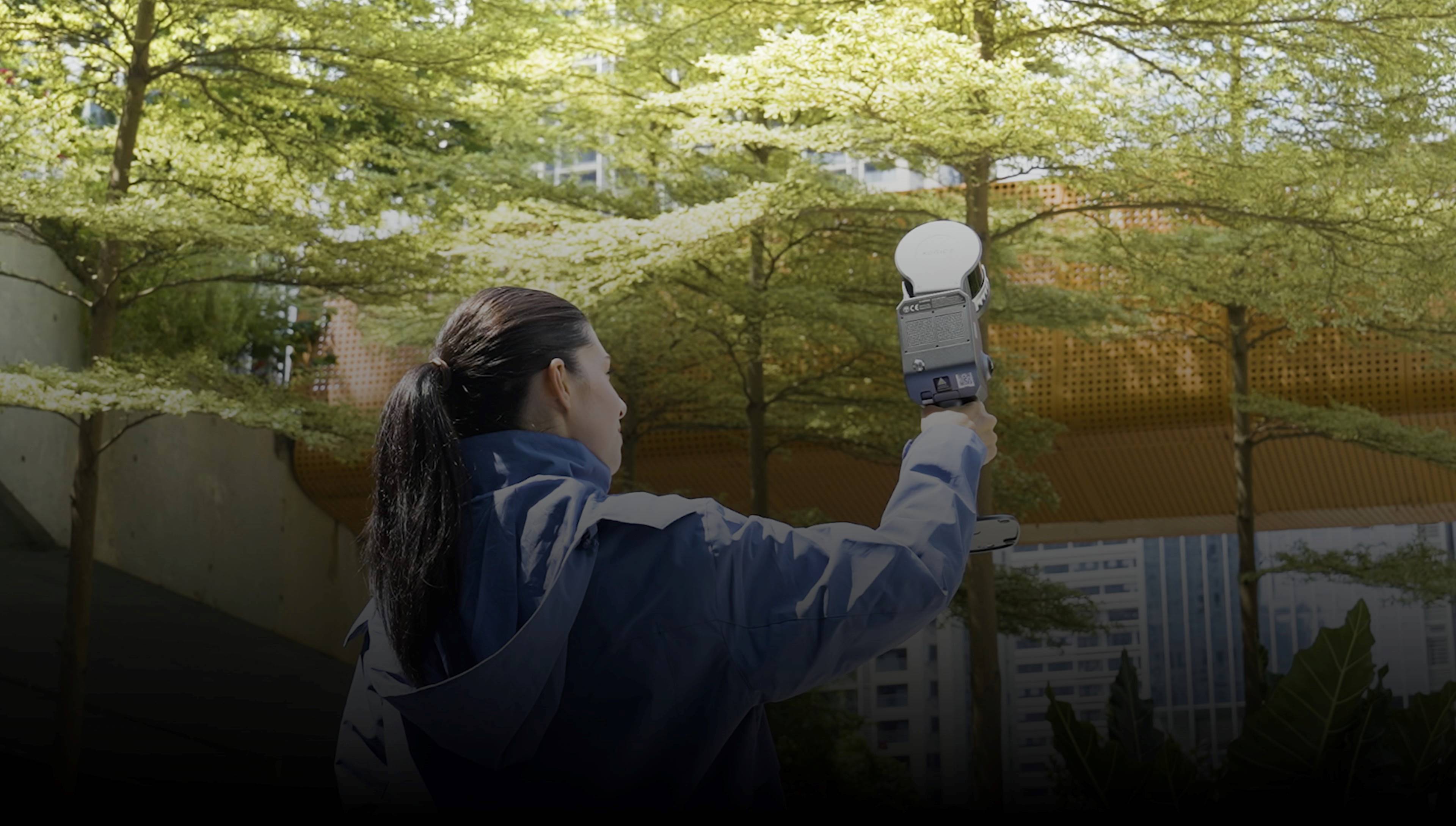 Operator using the Xgrids Lixel L2 Pro handheld SLAM scanner for outdoor building environment capture